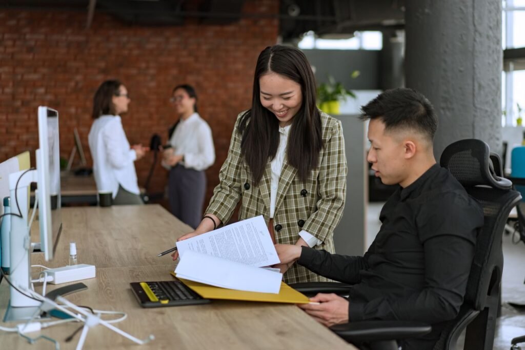 Scaling to 20+ Employees? Here’s Why Payroll Gets More Complex Professionals engaged in teamwork at a modern office desk reviewing documents.